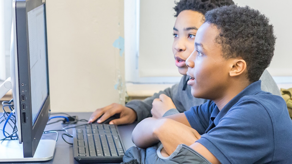 Boys in a classroom learning to code