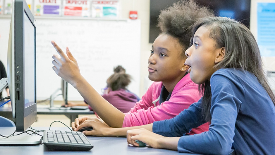 Girls in a classroom learning to code